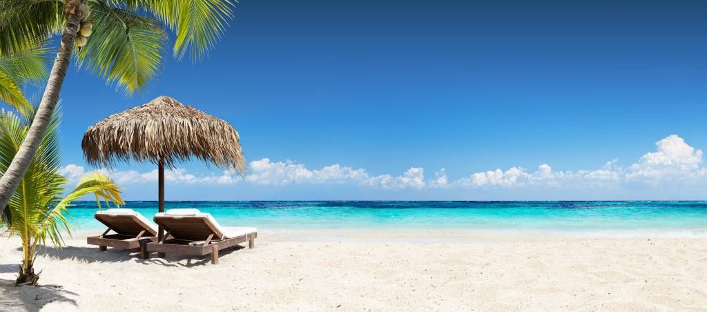 Stoelen en parasol op tropisch strand