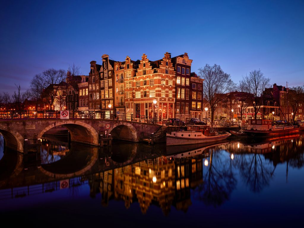 Verlichte huizen langs de gracht