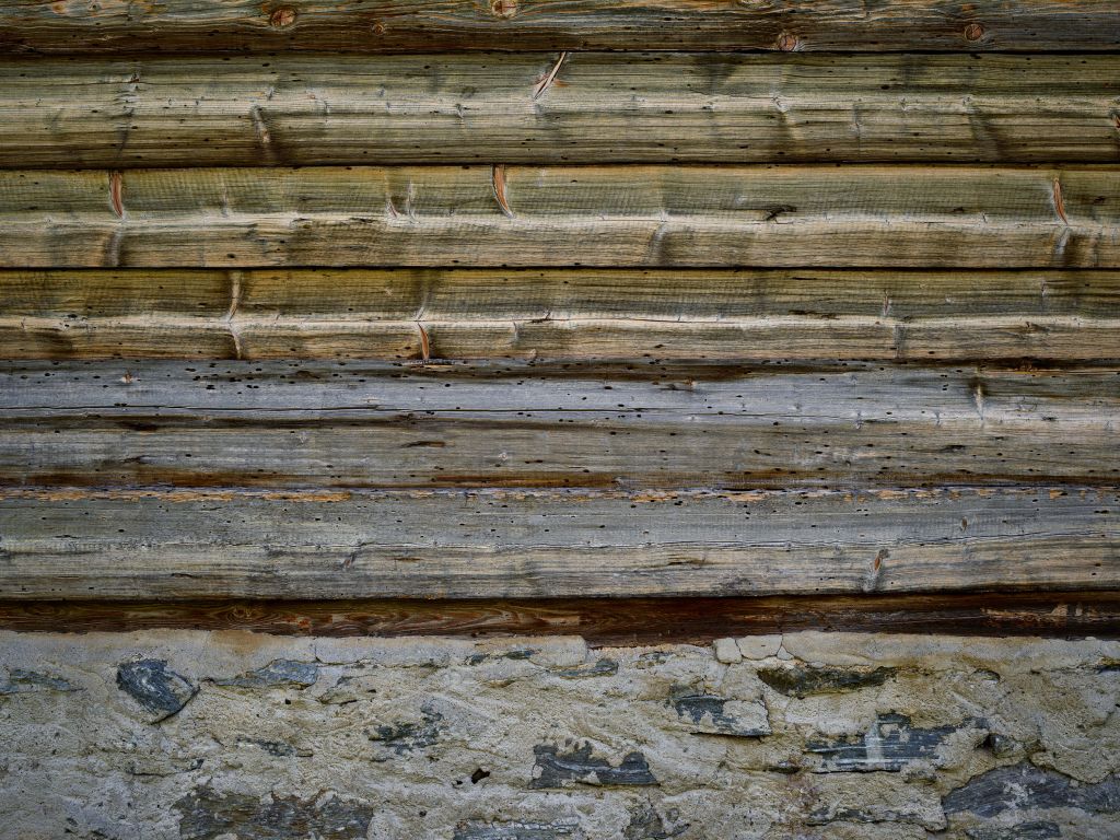 Verweerd hout op stenen muur