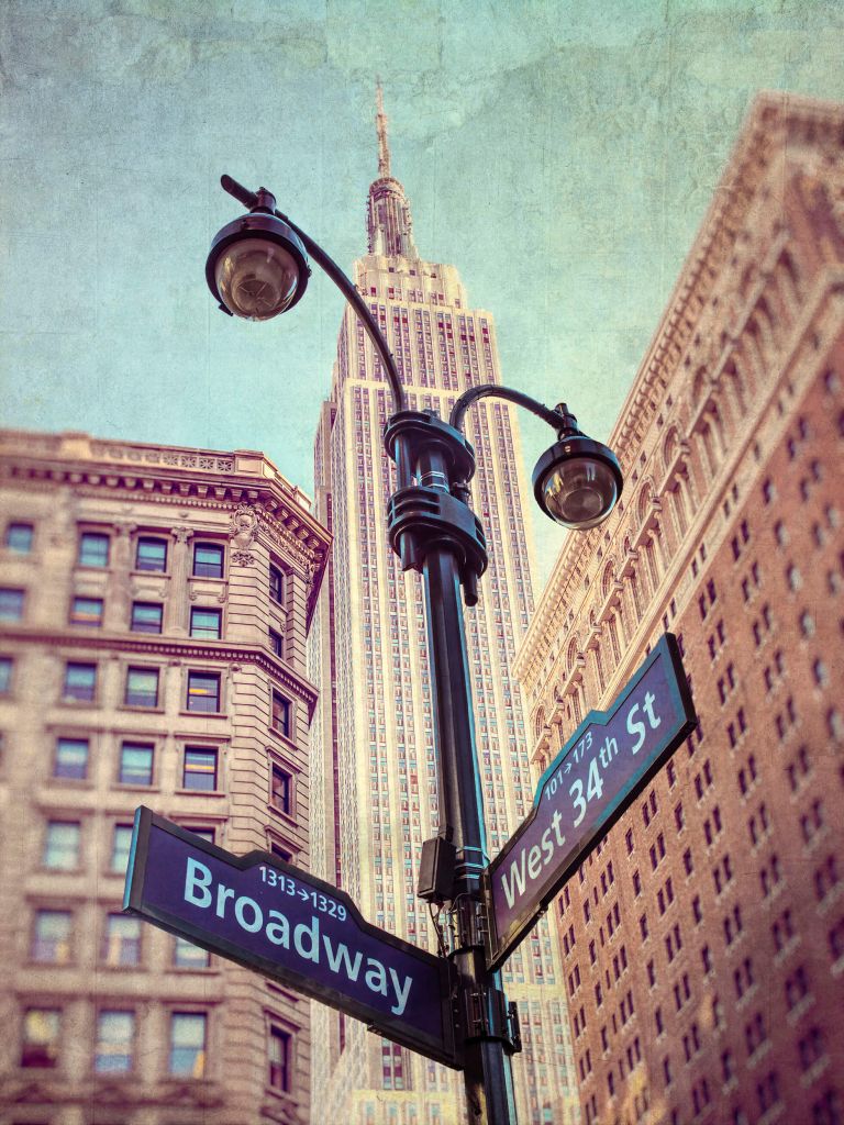 Street lamp and street signs with Empire State building in background - New York