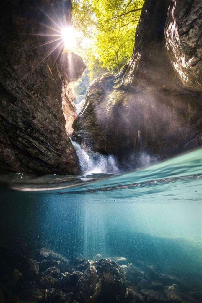 Zonlicht in bergkloof met waterval