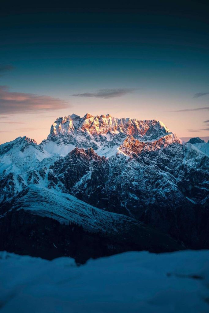 Avondlicht op besneeuwde bergtoppen