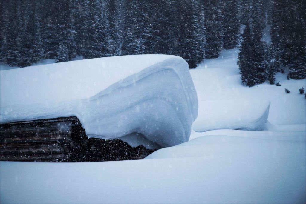 Besneeuwde alpenhut in winterstorm