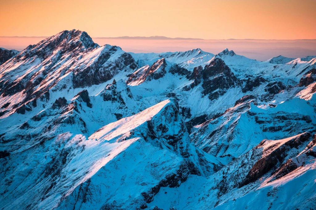 Zonsopkomst over besneeuwd bergmassief