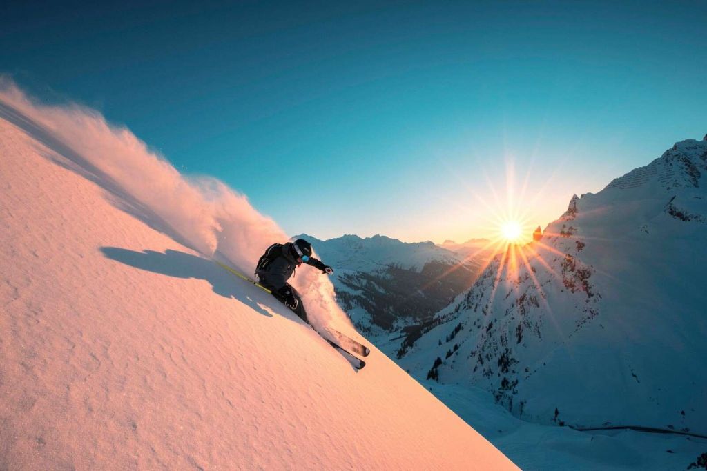 Sneeuwafdaling bij vurige zonsondergang