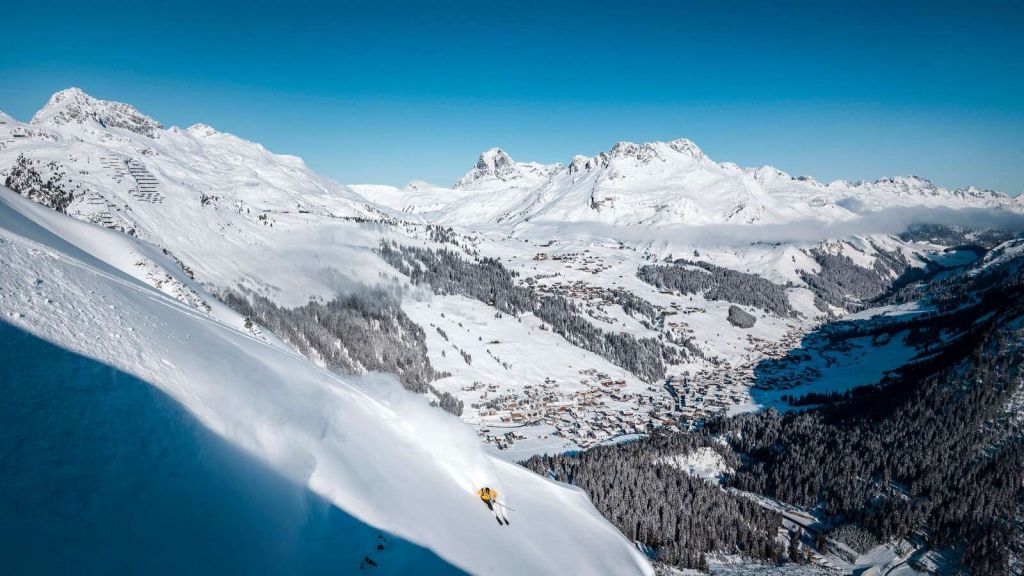 Afdaling boven alpendorp in sneeuw
