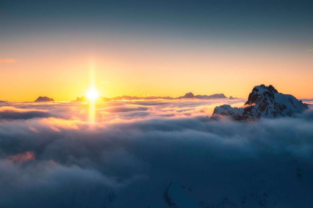 Zonsopkomst boven wolkenzee en bergtoppen