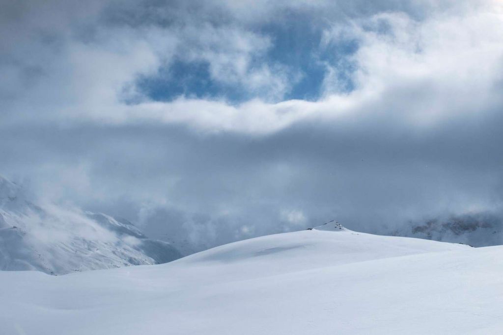 Besneeuwde heuvels onder dreigende lucht