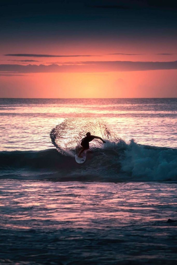 Surfer in de roze avondgloed
