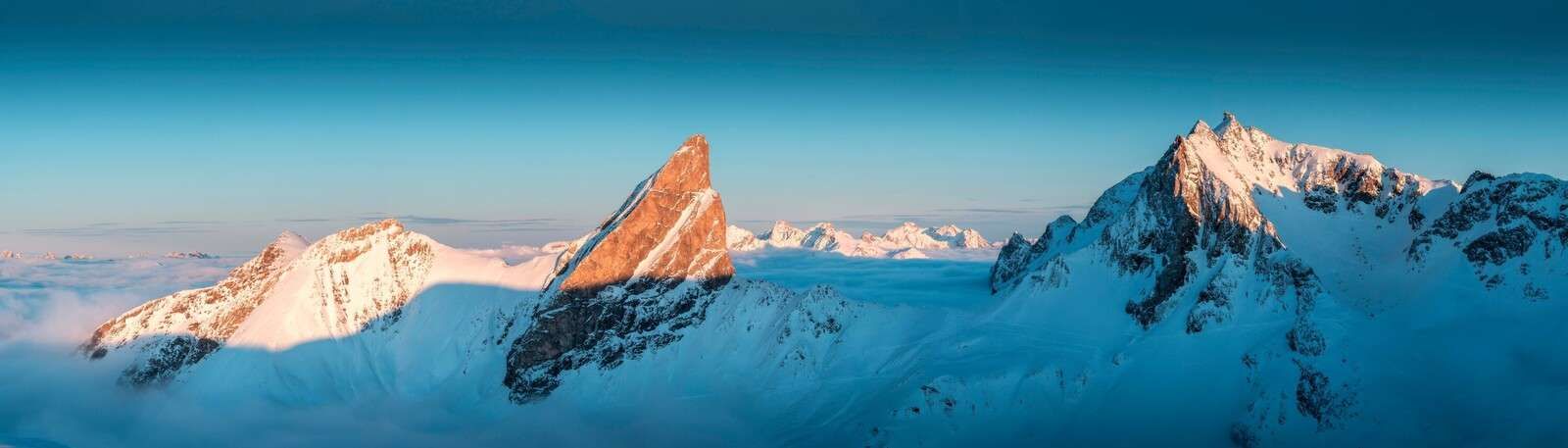 Ochtendlicht op besneeuwde bergkam