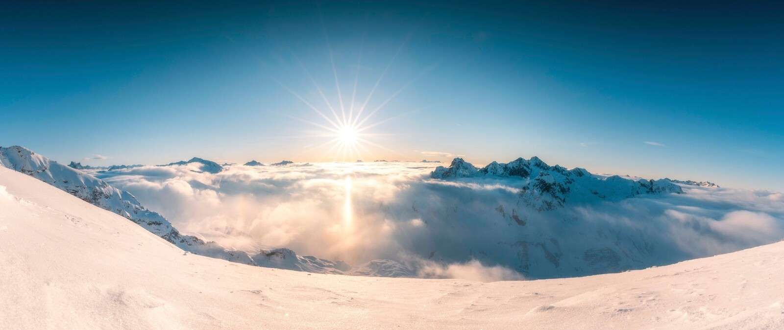 Zon boven wolkendek in alpenpanorama