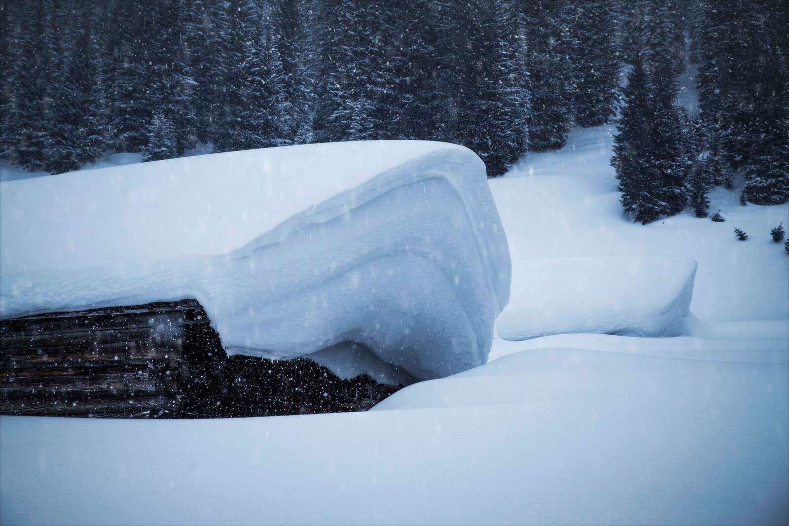 Besneeuwde alpenhut in winterstorm