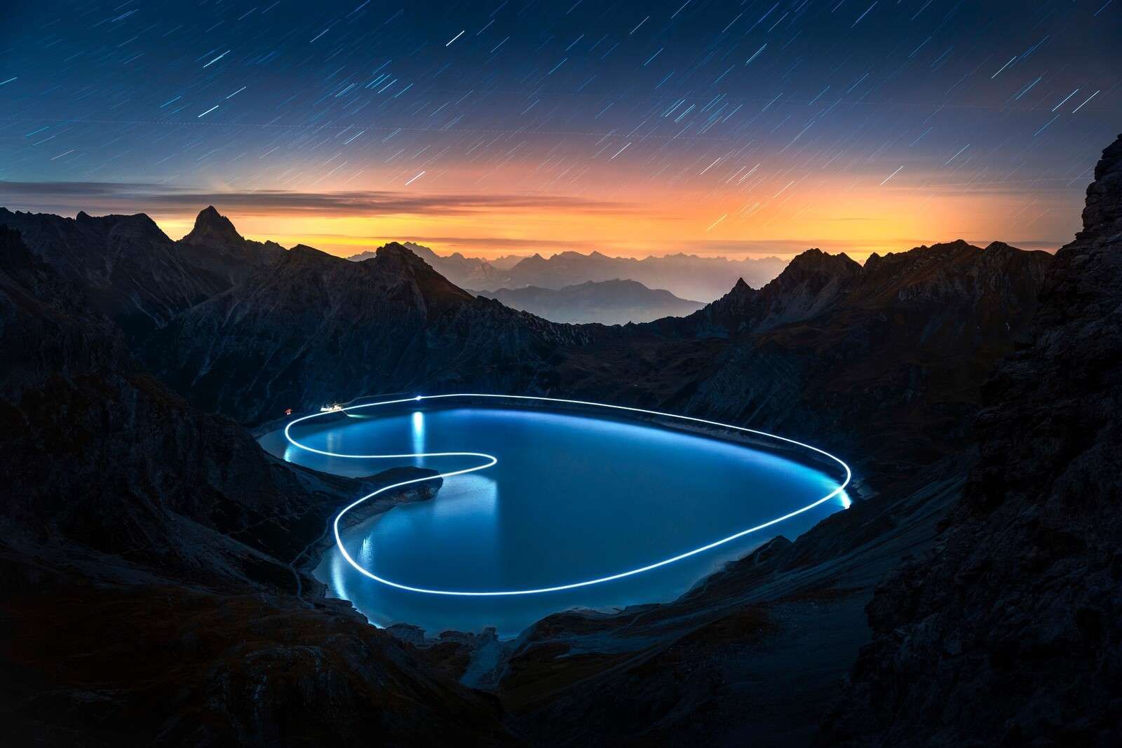 Lichtpad rond bergmeer bij nacht