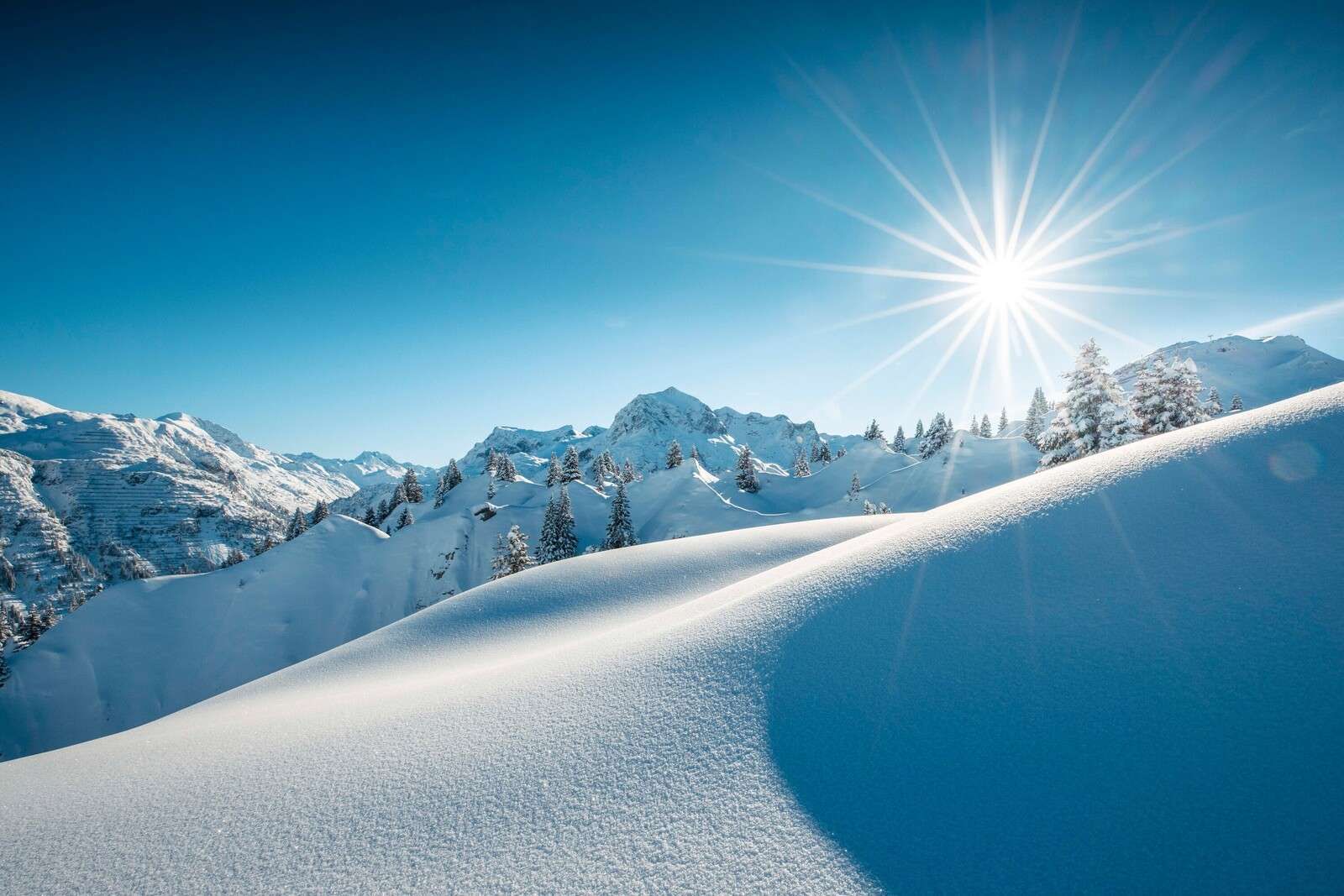 Zonlicht over glinsterende sneeuwheuvels