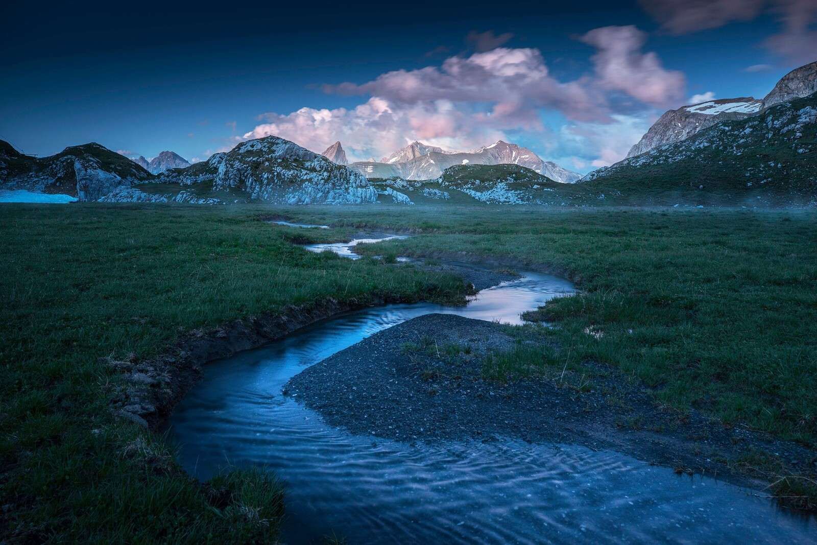 Avondlicht over bergvallei met beek