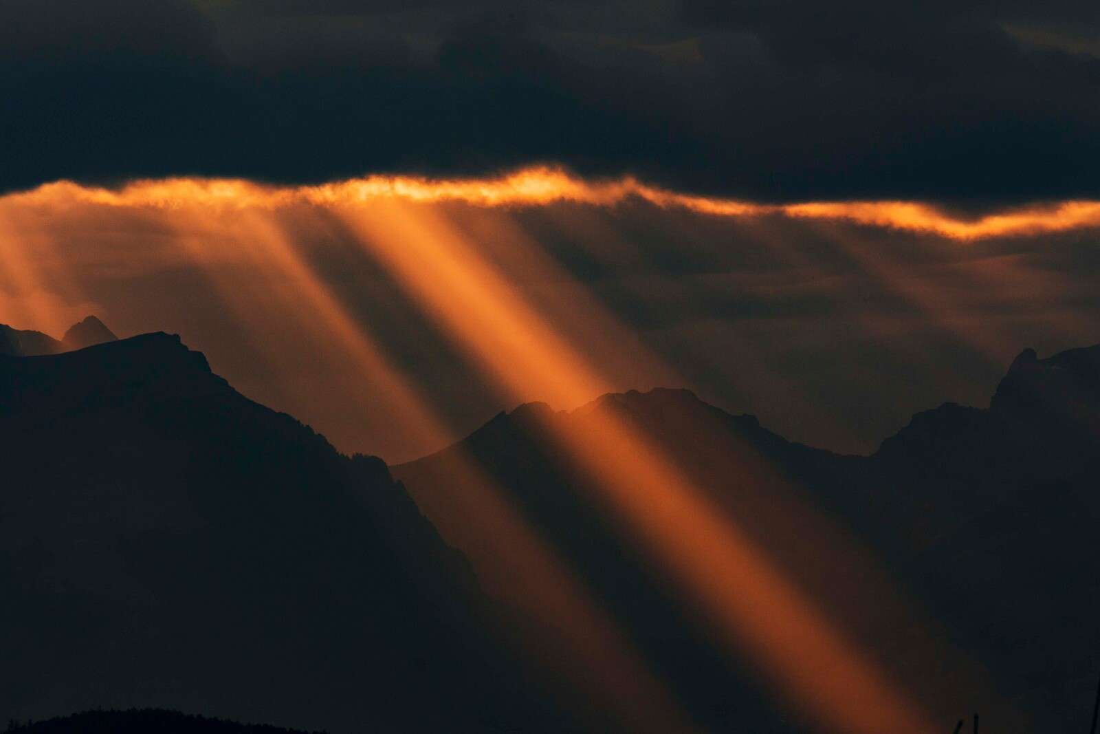 Gouden zonnestralen over bergsilhouet