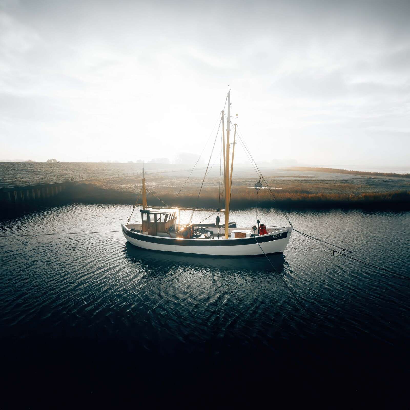 Visboot in ochtendlicht aan de kade