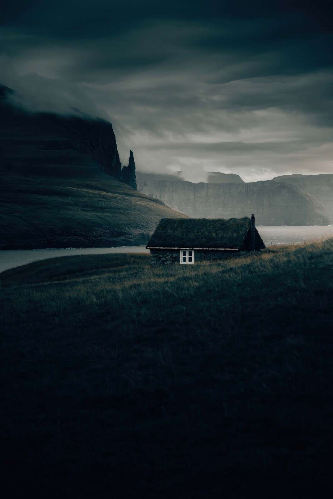 Huisje aan de voet van ruige fjorden